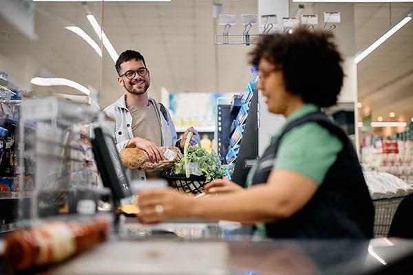 Mulher na caixa do supermercado, a ilustrar serviços e comércio e os produtos da Enzitools